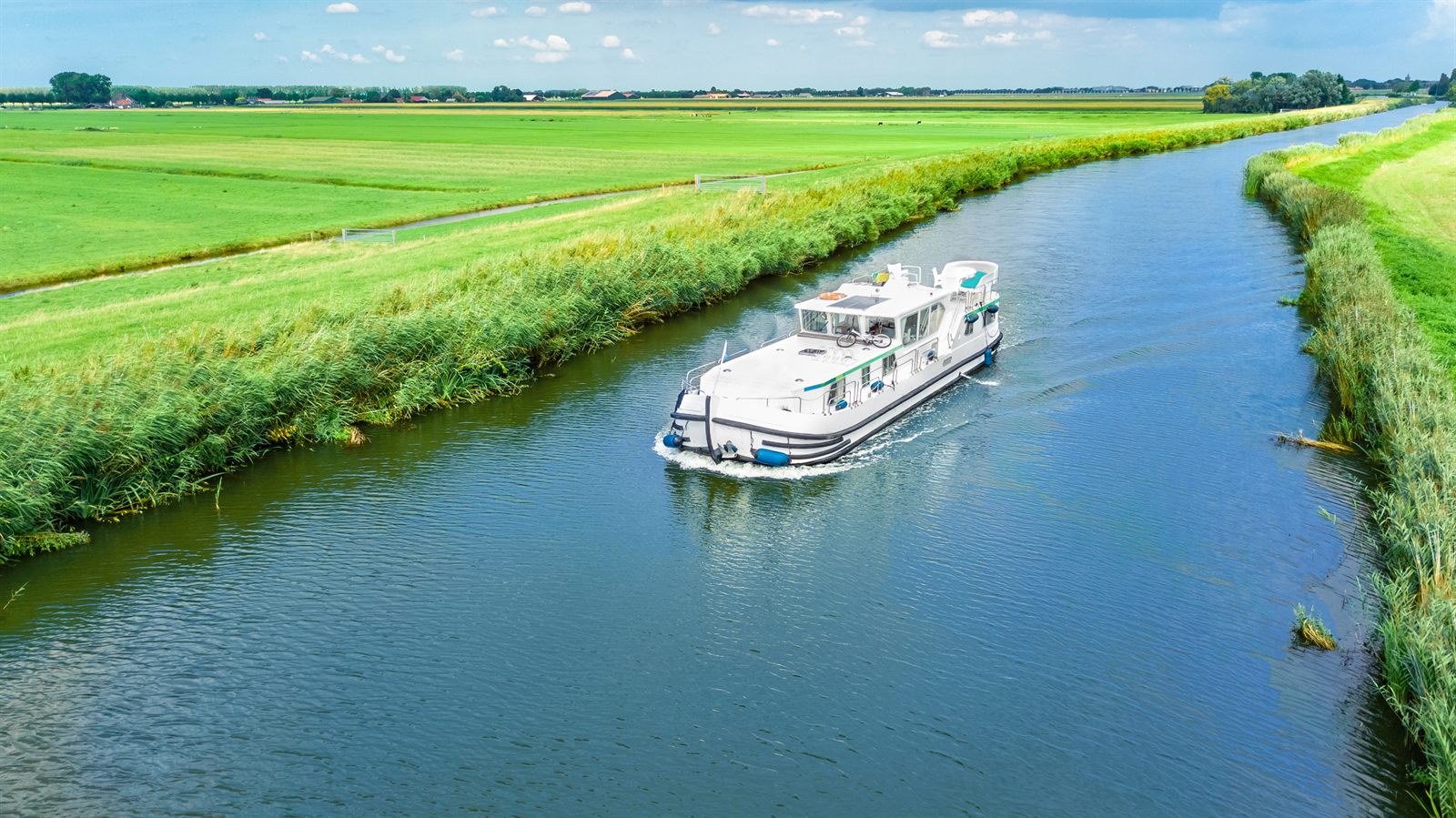 Small barge cruising a Dutch canal